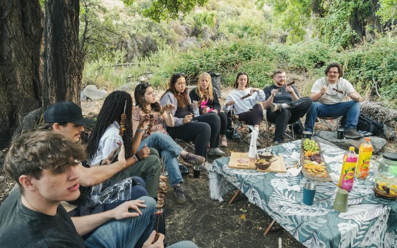 Group sharing lunch in the shade by the river in Yerba Loca