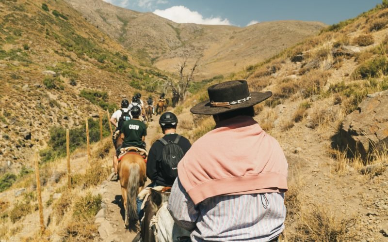 View from horseback on a canyon trail with a huaso leading ahead