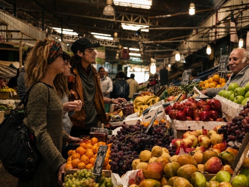 Travelers at La Vega market with local vendor and fresh produce