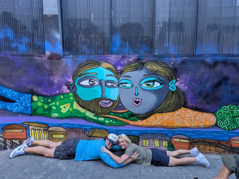 Group of travelers on Valparaíso's iconic painted staircase surrounded by street art murals