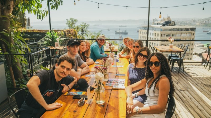 Group enjoying lunch on a rooftop terrace overlooking Valparaíso bay