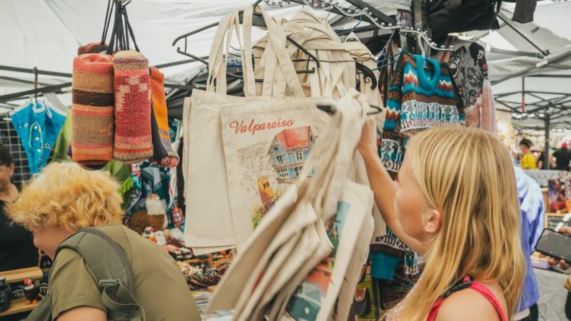 Traveler browsing Valparaíso-themed tote bags at the Viña del Mar artisan market